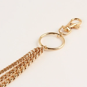 Close-up of golden multi-layer metal chains with lobster clasp for punk style trousers