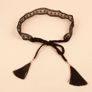Close-up of black lace waist belt with delicate fringe tassels and gold-tone metal clips