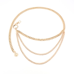 Detail view of gold layered waist chain with sun and moon celestial pendants