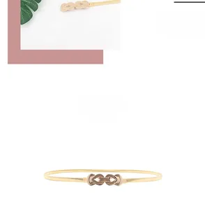Détail de ceinture élastique dorée en métal avec boucle géométrique pour robes de femmes