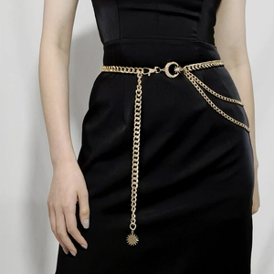 Detail of gold multi-layer chain belt with moon clasp and celestial sun charm pendant