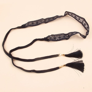 Close-up of woven lace belt featuring bohemian tassels and gold metal accents