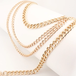 Close-up of triple-layered golden metal waist chain with moon and star pendants
