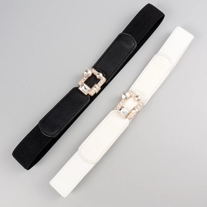 Close-up of gold rectangular buckles with rhinestones on black and white elastic belts
