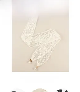 Détail de ceinture en dentelle blanche avec tissage floral et perles dorées