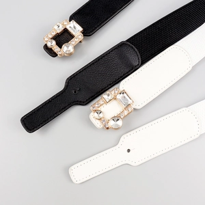 Close-up of elastic waist belts featuring sparkling rhinestone buckles in gold finish