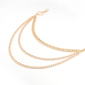 Detail of triple-layer gold metal waist chain with moon and star pendant charms