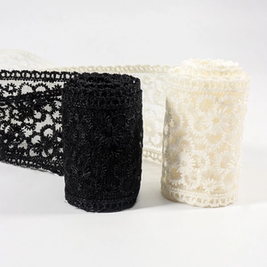 Détail de bordure en dentelle florale noire et beige avec broderie élégante de marguerites
