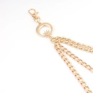 Close-up of golden triple-layered metal waist chain with moon and star pendant