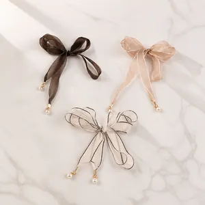 Lace ribbon detail with elegant pearl pendants available in black, white, and champagne