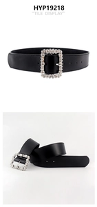 Black leather belt featuring a large rectangular buckle with sparkling rhinestones