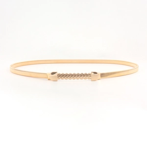 Detailed view of women's gold spring metal belt with a wavy decorative buckle