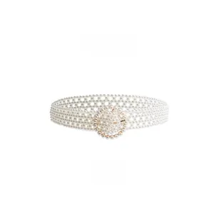 Close-up of elegant white pearl waist belt with a sparkling rhinestone round buckle