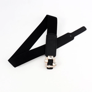 Close-up of geometric gold alloy buckle with sparkling rhinestones on black elastic belt