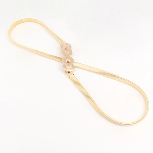 Détail de la ceinture dorée en métal élastique avec boucle à double anneau évidé