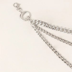 Detail of silver layered metal waist chain featuring moon and star charms with lobster clasp