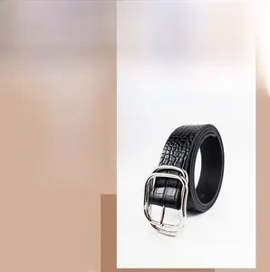Detailed close-up of black faux crocodile texture belt with silver metal double ring buckle