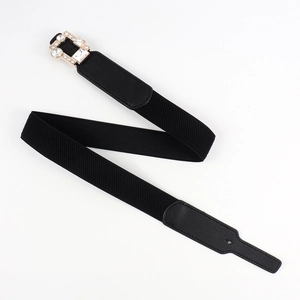 Detailed view of women's elastic belt with luxury rhinestone encrusted gold buckle