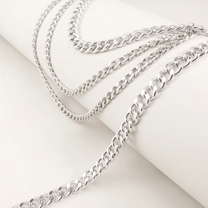 Detailed macro view of four tiered silver metal curb chains with high glossy finish