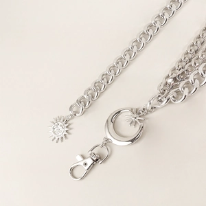 Detail of silver sun and moon star pendants on a heavy curb metal waist chain