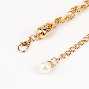 Detail of gold woven chain with white pearls and luxury rhinestone lobster clasp