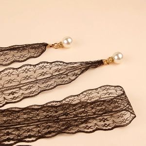 Detalle de cinta de encaje negro con colgante de perlas y pedrería para vestidos