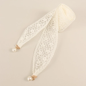 Close-up of white floral lace belt with gold metal tips and elegant pearl pendants