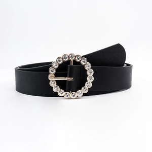 Women's black leather belt featuring a golden round buckle with sparkling rhinestones
