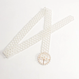 Detailed close-up of an elegant pearl belt with a round decorative buckle for dresses