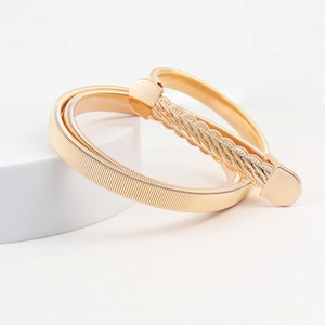 Close-up of golden elastic metal waist belts featuring textured spring and woven patterns