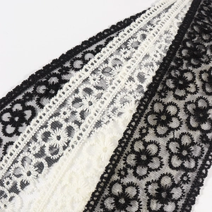 Détail de la ceinture en dentelle marguerite noire et blanche avec broderie de perles