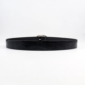 Detail of black faux crocodile pattern leather belt with a sleek silver metal buckle