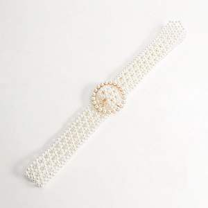 Detailed macro of woven white pearls on a belt with a golden circular buckle for dresses