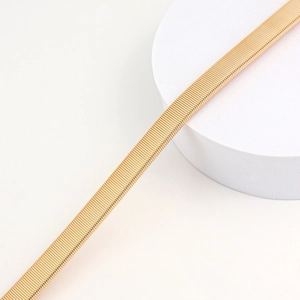 Macro detail of elegant gold wavy metal chain belt texture for women's fashion waist