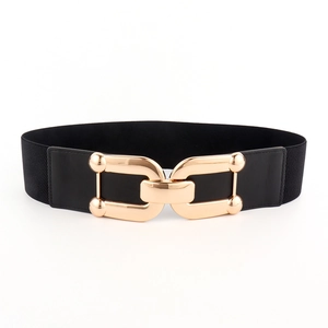 Detail of interlocking gold geometric buckle on black elastic waist belt for dresses