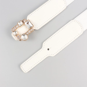 Macro detail of white elastic waist belt featuring a rectangular crystal-encrusted buckle