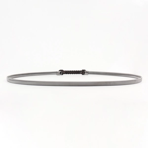 Detail of silver stretch metal chain belt with a sleek black capsule buckle closure