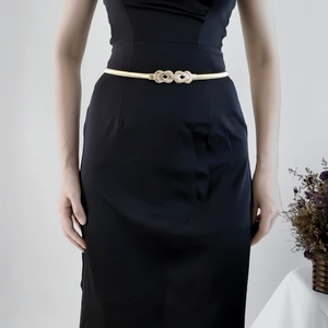 Chaîne de taille dorée élastique élégante avec boucle fleur sur une robe noire