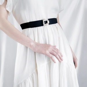 Close-up of a luxury rhinestone buckle on a black elastic belt for summer dresses