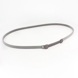 Detailed macro view of black metal snake chain belt with textured woven buckle closure