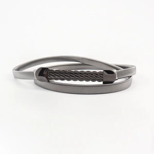 Detail view of gun-black metal spring belt showing wave-textured buckle and fine coil structure