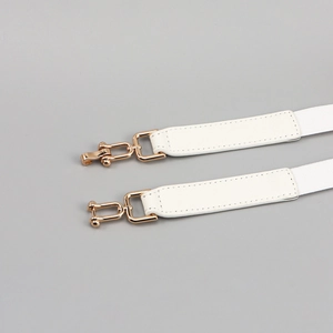 Dettaglio tracolle in pelle bianca con fibbie in metallo a U dorate lucide