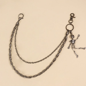 Détail de la chaîne de pantalon double en métal noir avec pendentif crâne et mousquetons