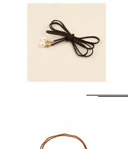 Close-up of woven waist chain featuring elegant pearl pendants in black and brown