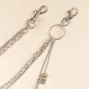 Close-up of silver multilayer metal pants chain with engraved mind portrait tag