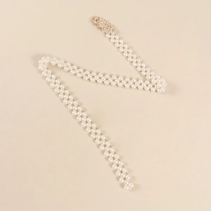 Dettaglio della catena in perle elastiche con fibbia a cuore dorata e strass