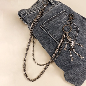 Détail de la double chaîne de pantalon punk en métal avec pendentif tête de mort