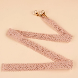 Primer plano detallado del cinturón de encaje rosa con colgante de perla y cristal