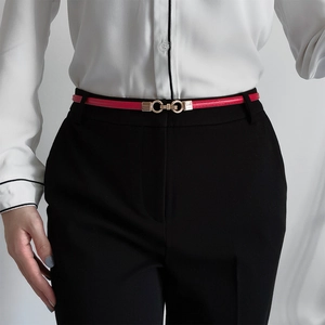 Detail of red skinny belt with golden double ring buckle worn on white shirt