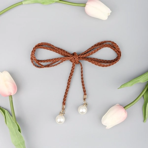 Detail of bohemian brown braided rope belt with elegant pearl pendants and bow knot style